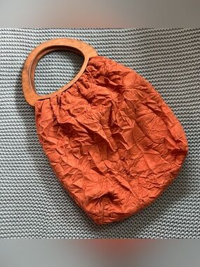 Vintage orange crinkled fabric handbag, wood handle and floral pattern inside